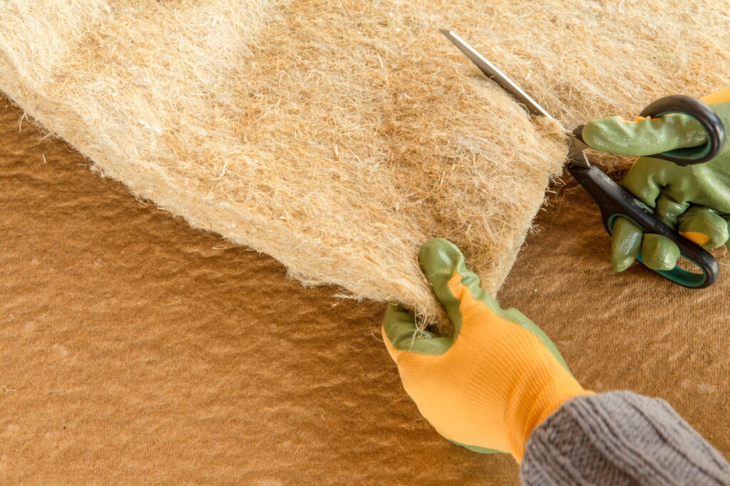 gloved hand cutting compressed hemp fiber