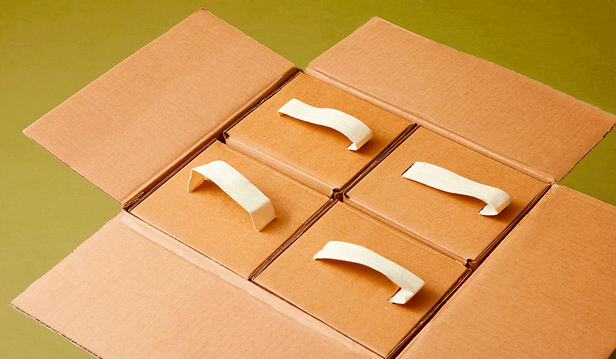 Innovative cardboard packaging with pull tabs for easy opening on a green background.