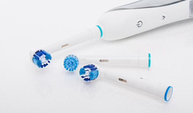 Electric toothbrush and replacement heads on a snowy background